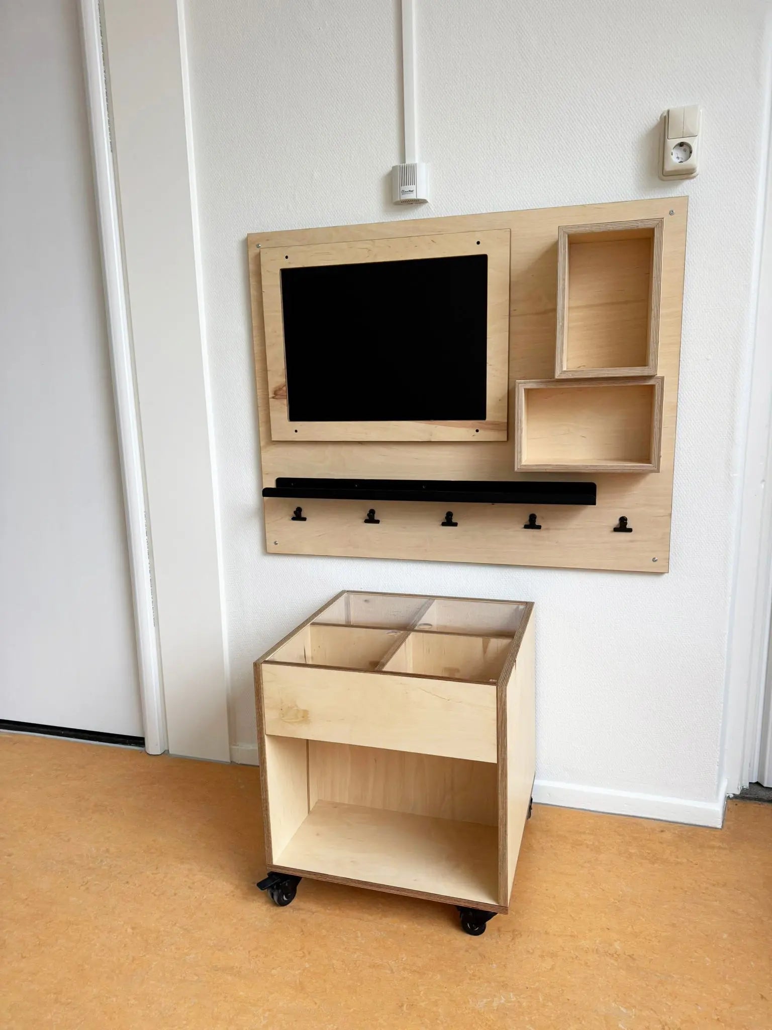 thematafel met vakken onder plexiglas aan bovenzijde, op wielen